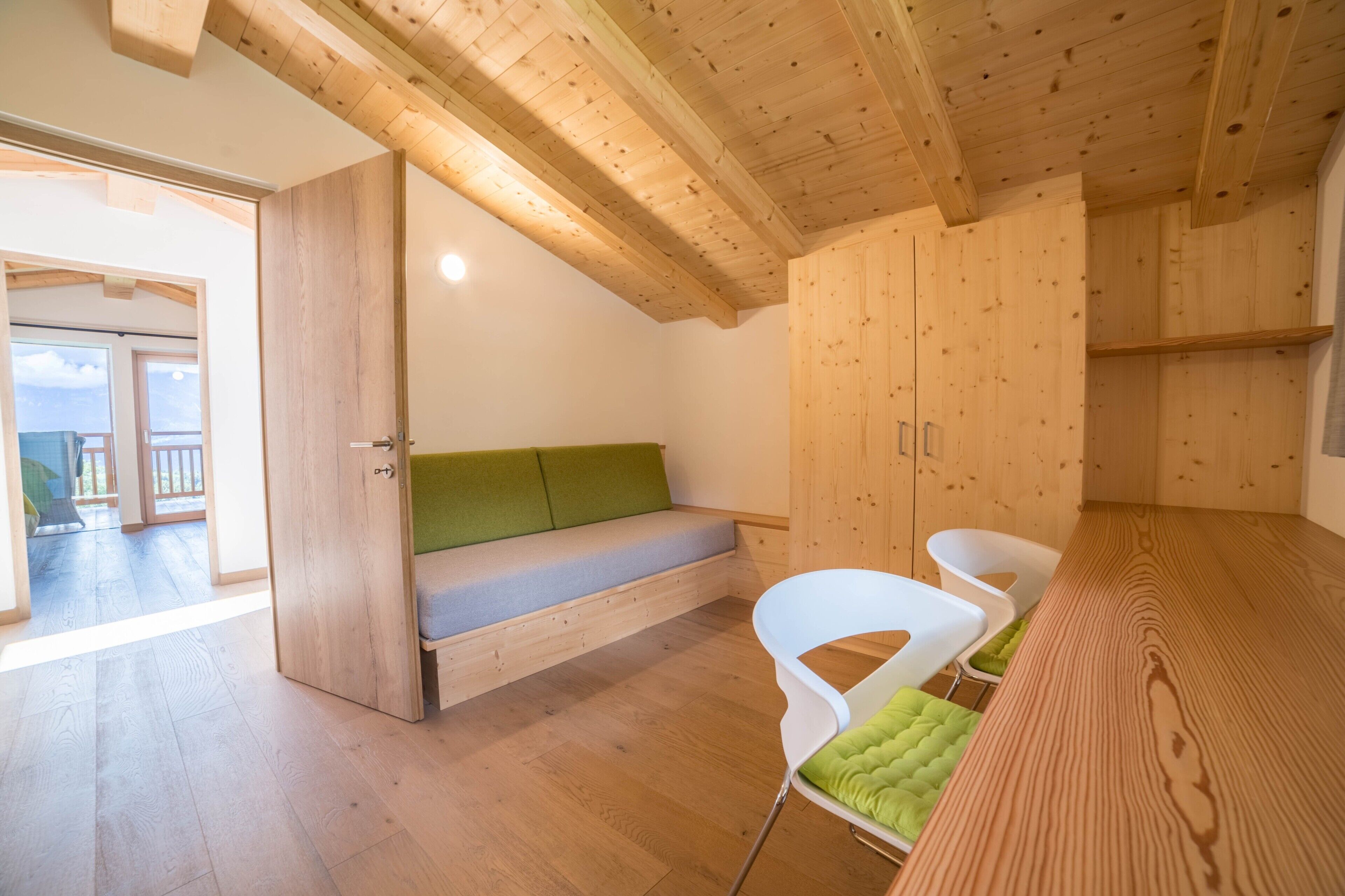 Un intérieur en bois avec un banc, des chaises et une table en bois.