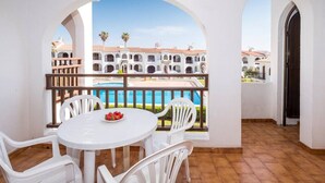 A balcony with a pool view, white furniture, and arches. - Apartment in Complex with Pool - Girasol Garden Superior 2 C (Menorca)
