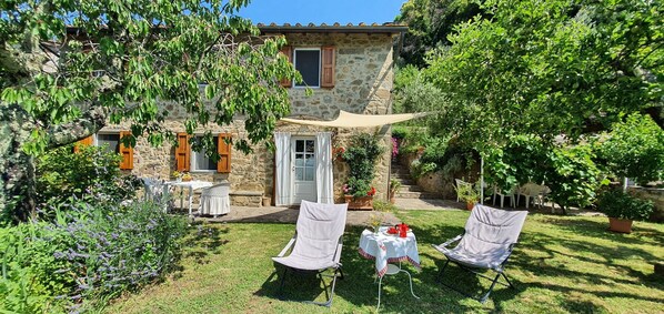 A stone house with a garden patio, outdoor seating, and a variety of plants. - Stunning private villa with internet, A/C, hot tub, TV, pets allowed, panoramic view, close to Lucca (Petrognano)