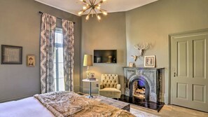 A bedroom with a bed, a fireplace, a chair, and a television. - Historic charm in St. Elmo 3BR/3BA situated on over an acre at base of Lookout (Chattanooga)