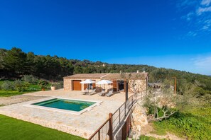 A stone villa with a swimming pool, outdoor seating, and a view of the surrounding hills. - Rural Home "Can Jaume" with Pool, Terrace, Mountain View & Wi-Fi (Manacor)