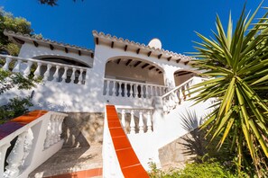 A white building with balconies and a staircase. - Stunning sea view and pool – Villa Amoura (San Jaime Mediterráneo)
