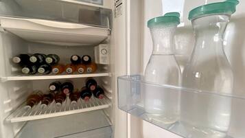 A refrigerator with shelves containing bottles and a water dispenser.