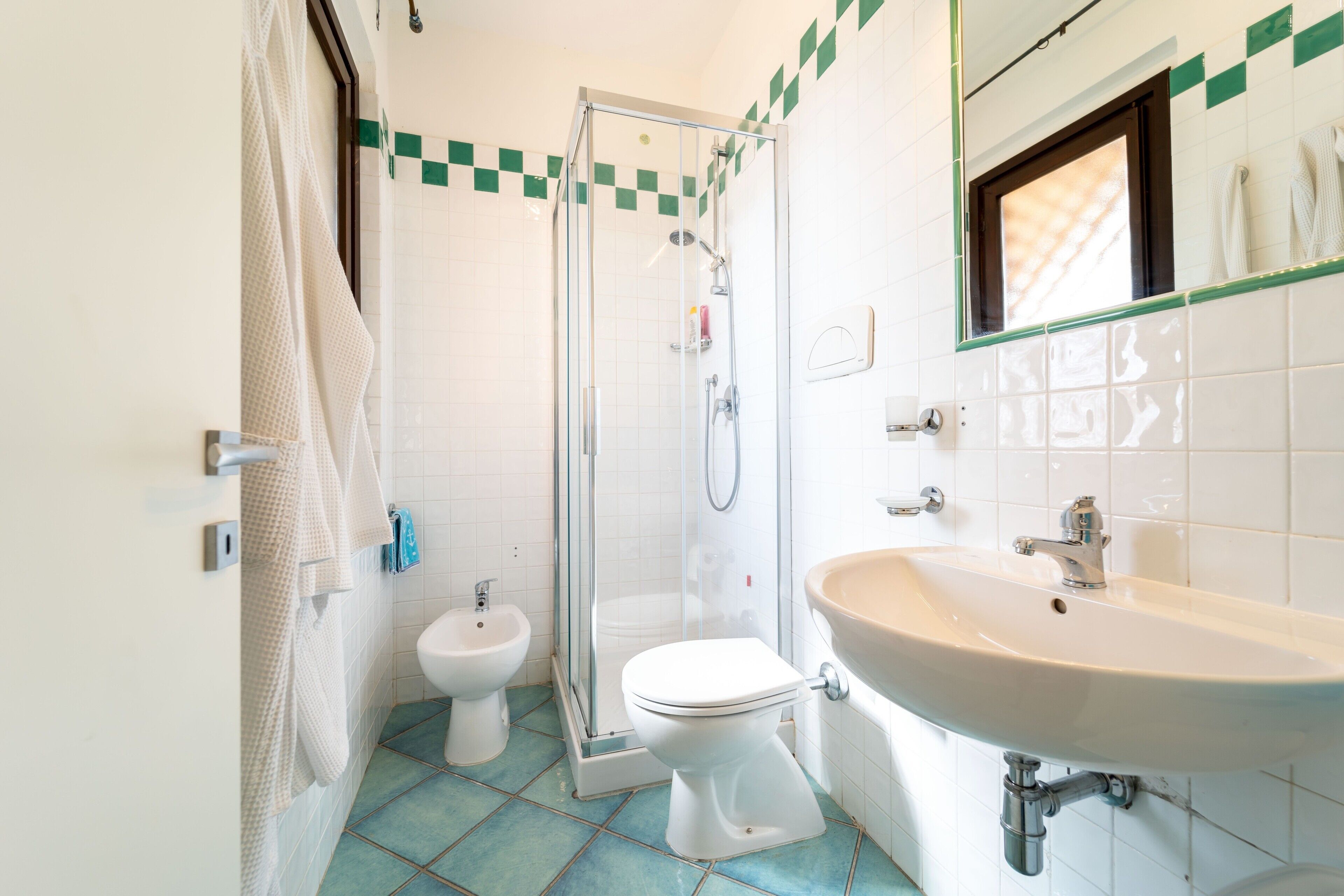 Un baño con ducha, inodoro, bidé y lavabo.