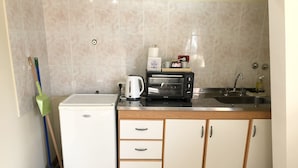 A compact kitchen with a microwave, toaster, and sink. - A un paso de todo Lo de Richard (Ushuaia)