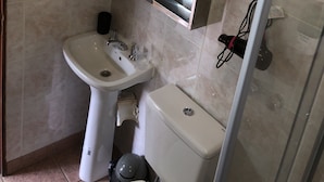A bathroom with a white sink, a toilet, and a mirror. - A un paso de todo Lo de Richard (Ushuaia)