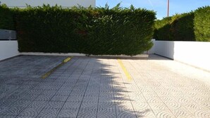 Une terrasse sur le toit, dotée d’un sol à motifs, d’une haie et d’un lampadaire.