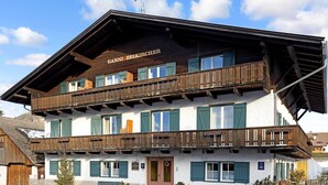 A two-story building with a wooden facade, balconies, and a sign reading 'GARNI BEIKIRCHER'.