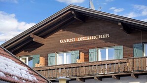 A wooden building with a balcony and a sign that reads 'Garni Beikircher.'