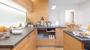 A modern kitchen with wooden cabinets, a black countertop, and various kitchen appliances.