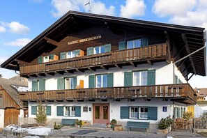 A two-story building with a wooden facade, balconies, and a sign reading 'GARNI BEIKIRCHER'. - Holiday Apartment “Kruma - Gsail 2” with Mountain View, Wi-Fi & Balcony (Olang)