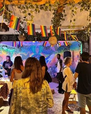 A vibrant event with a colorful backdrop and attendees. - Chamos Hostel Cultural (Arraial do Cabo)