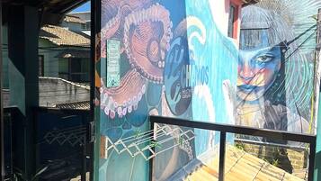 A mural with an octopus and a face, a hanging light fixture, and a metal gate.