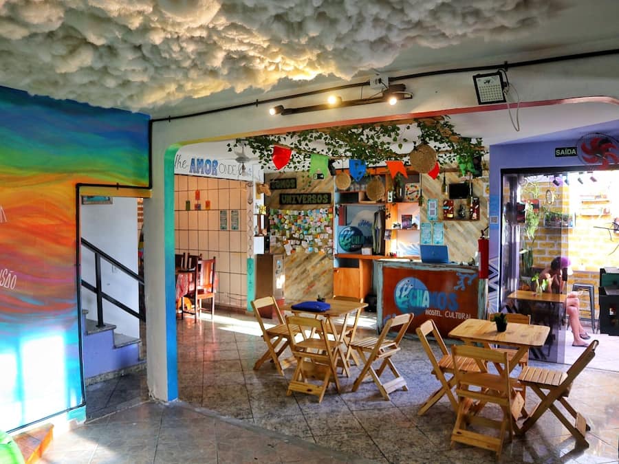 A hostel interior with a colorful mural, wooden furniture, and a cozy atmosphere.