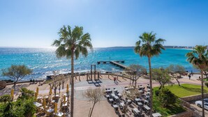 A coastal area with a pier, palm trees, and outdoor seating by the sea. -  Central Apartment at the Beach Promenade with Wi-Fi and Sea View (Cala Millor)