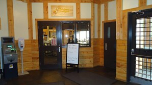 A restaurant interior with wooden walls, a chalkboard menu, and a cash register.