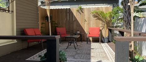 A wooden deck with outdoor furniture, a pergola, and potted plants.