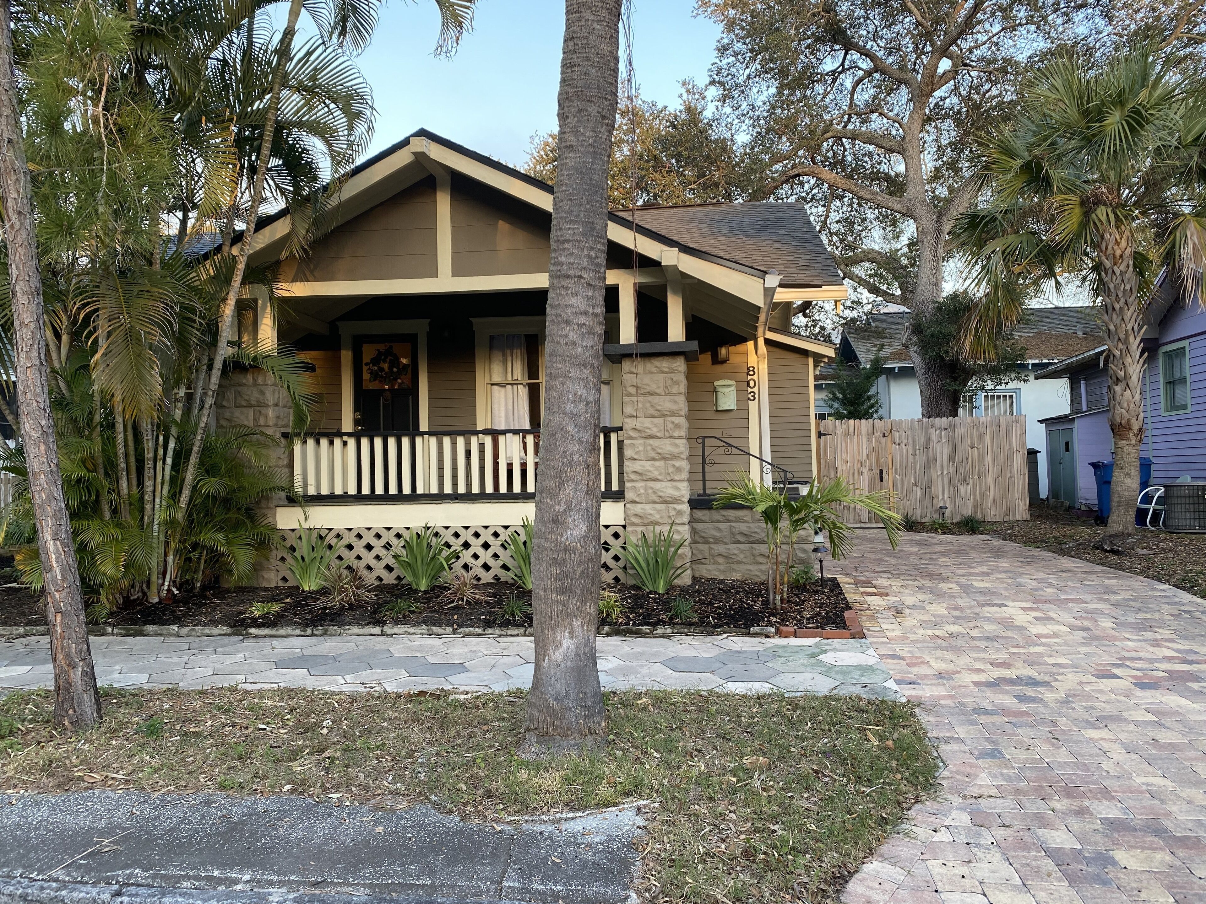 A two-story house with a front porch, stone foundation, and a mailbox.