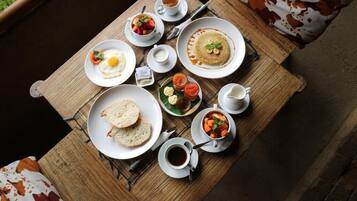 A breakfast table with various dishes including eggs, pancakes, toast, and soup.