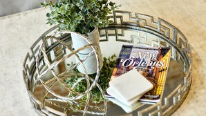 A decorative glass tray with a white pot and a book titled "Official Visitors Guide 2019".