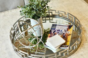 A decorative glass tray with a white pot and a book titled "Official Visitors Guide 2019".