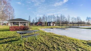 A park with picnic tables, a gazebo, and small cabins.