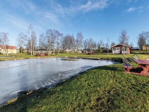 A frozen pond with a gazebo, picnic tables, and houses in the background. - Viljami by Interhome (Kaustinen)