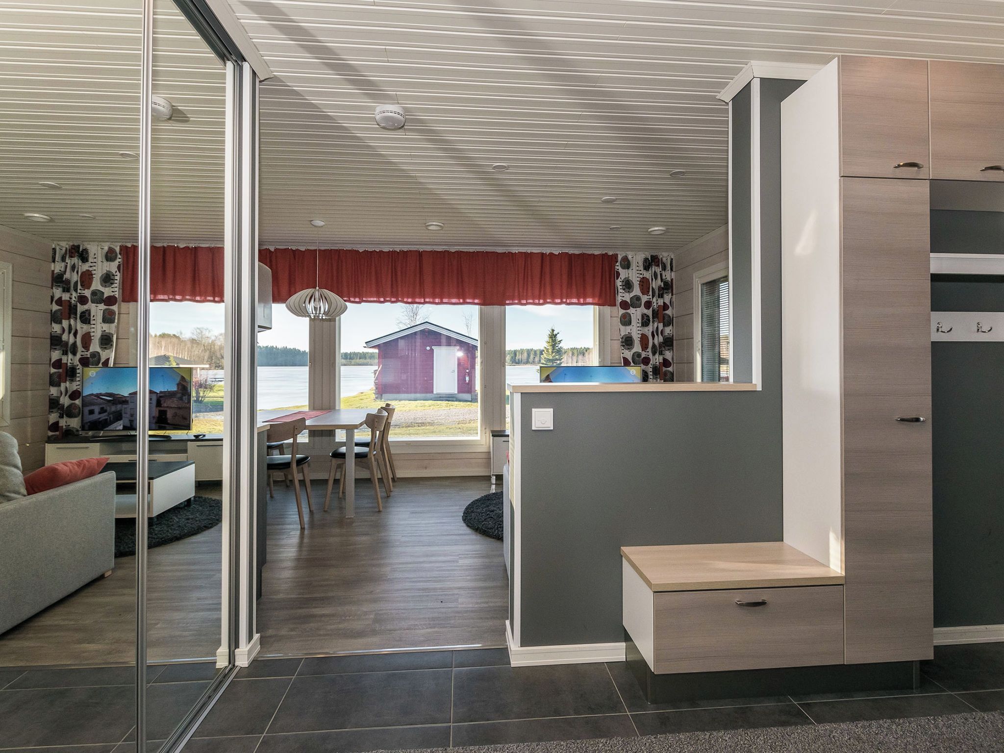 Eine moderne Küche mit Essbereich, einer Couch und Seeblick.
