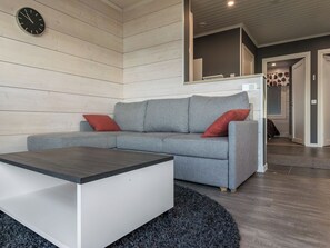 A modern living room with a grey sectional sofa, a white coffee table, and a round rug. - Viljami by Interhome (Kaustinen)