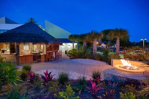 Relax in a serene garden setting with a fire feature and casual bar area.