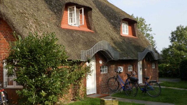 A thatched-roof house with a brick base, two windows, and a bicycle parked outside. - House Marsh Chick, Wrixum (Wrixum)