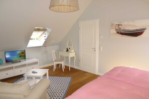 A bedroom with a bed, a desk, a chair, a television, and a window. - Villa De Meere, Apartment 8, Nieblum (Nieblum)