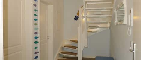 A staircase with white railings and a blue carpeted landing area.