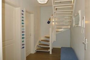 A staircase with white railings and a blue carpeted landing area. - Villa De Meere, Apartment 8, Nieblum (Nieblum)