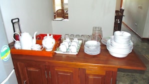 Una encimera de cocina con diferentes platos, una tetera y una cafetera.
