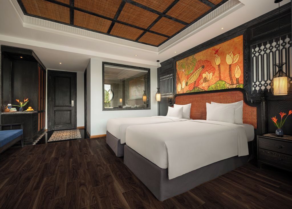 Habitación de hotel con una cama grande, un escritorio y vistas al exterior.
