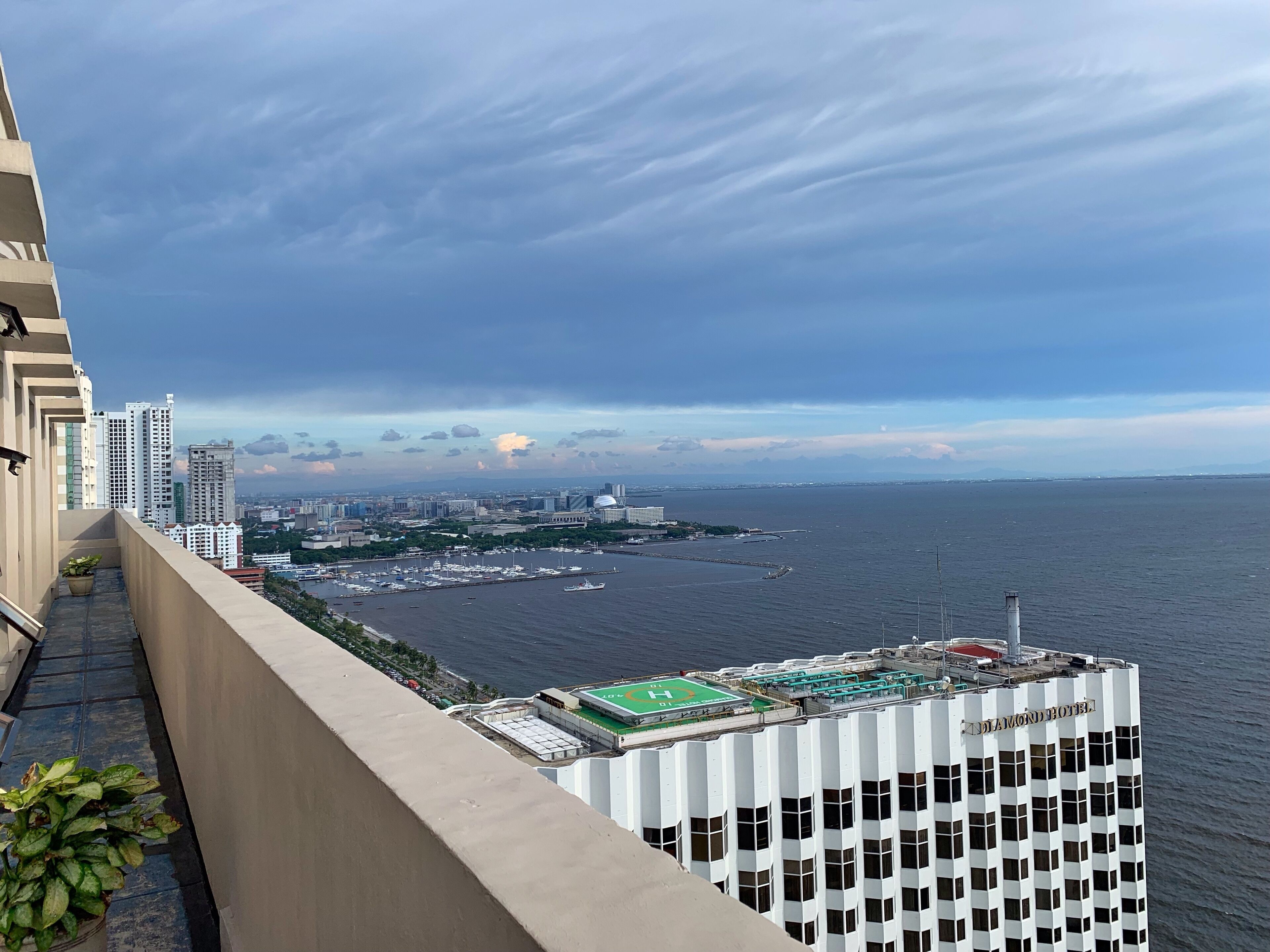 A high-rise hotel with a view of a marina and cityscape.