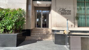 The entrance to Marina Residential Suites, featuring a glass door, a sign with the suite name, and a staircase leading up to the entrance. - Marina Residential Suites (Manila)