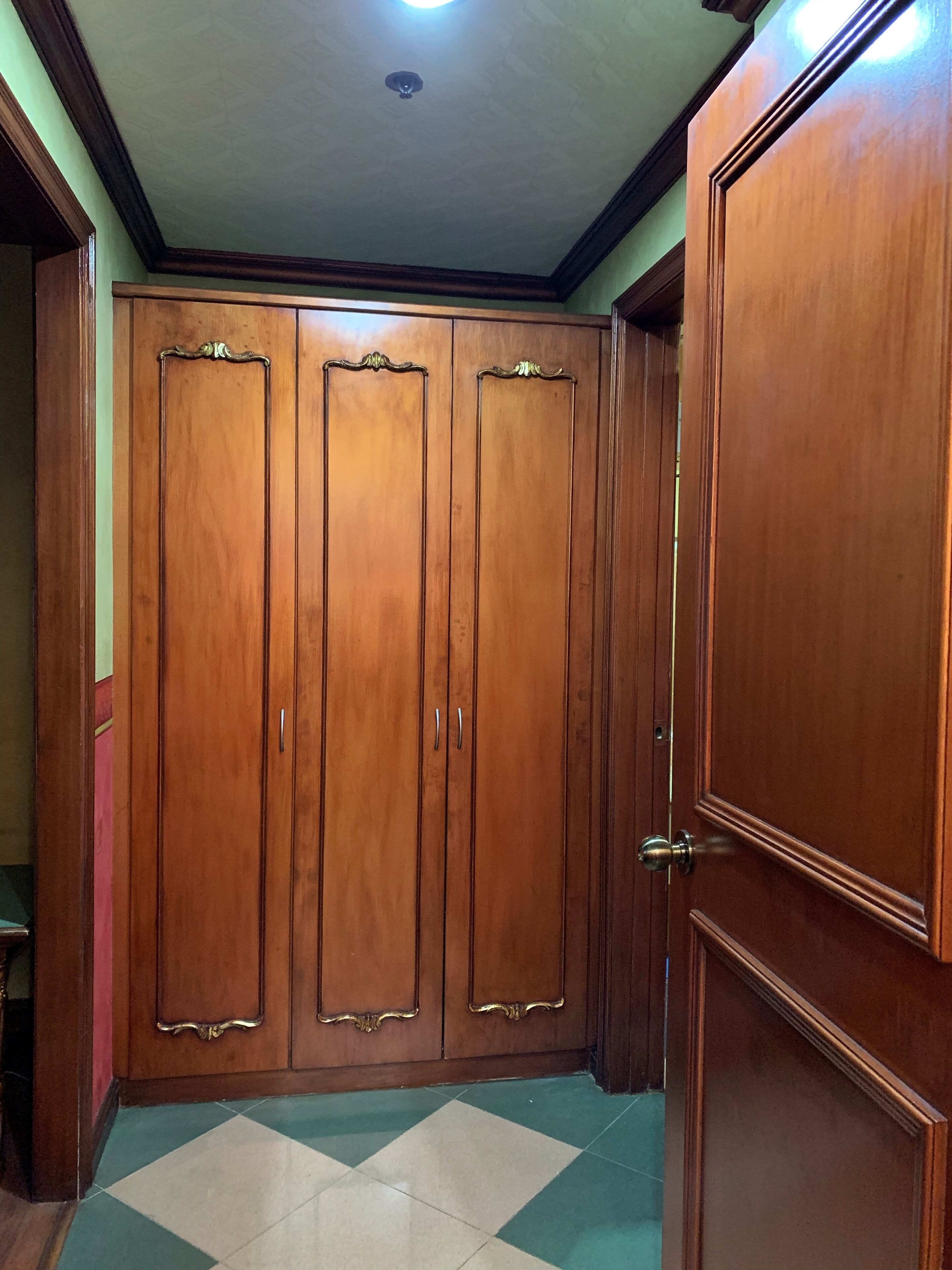 Un armario de madera con espejo y puerta.