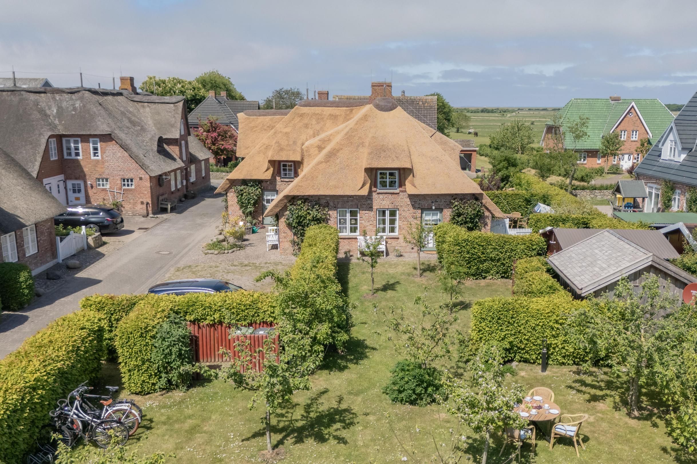 A residential area with houses, a bicycle, and a dining table in the yard.