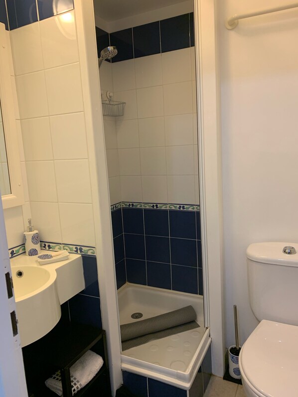 Une salle de bain équipée d’une douche, de toilettes, d’un lavabo et d’un porte-serviettes.