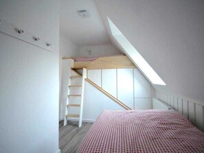 A bedroom with a bunk bed, a wooden ladder, a skylight, and a white wall. - Kliffkoje, Guatingwai 12 Foehr (Nieblum)
