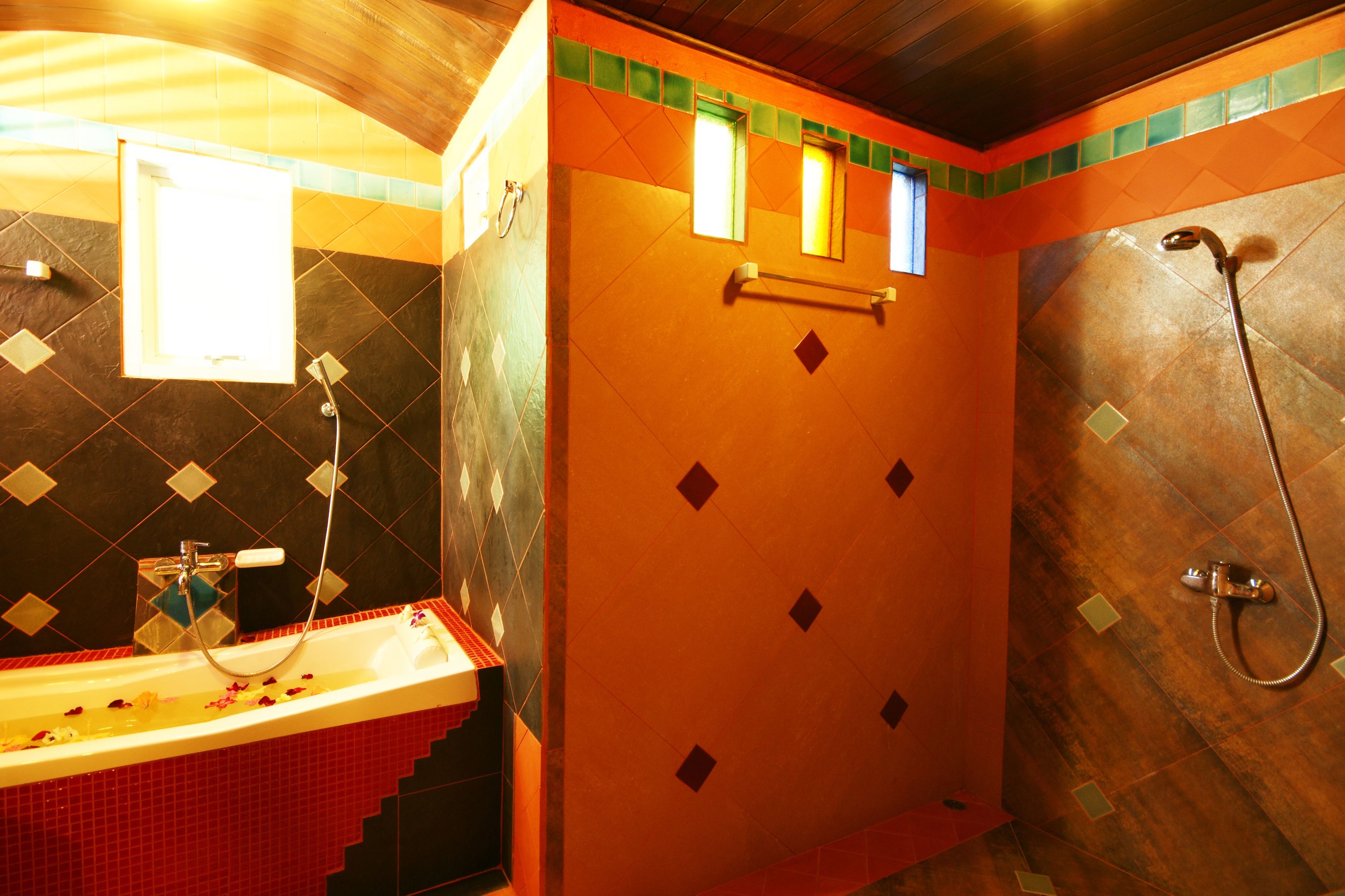 A bathroom with a red sink, a shower, and a mirror.