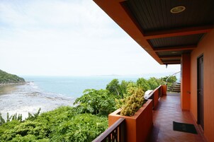 Un balcón con vista al mar y un paisaje montañoso.