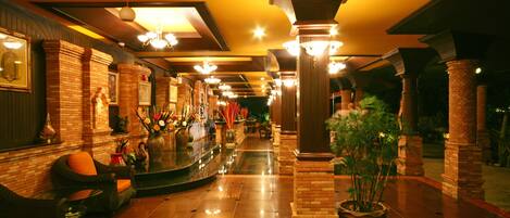 A hotel lobby with a bar area, seating, and a potted plant.