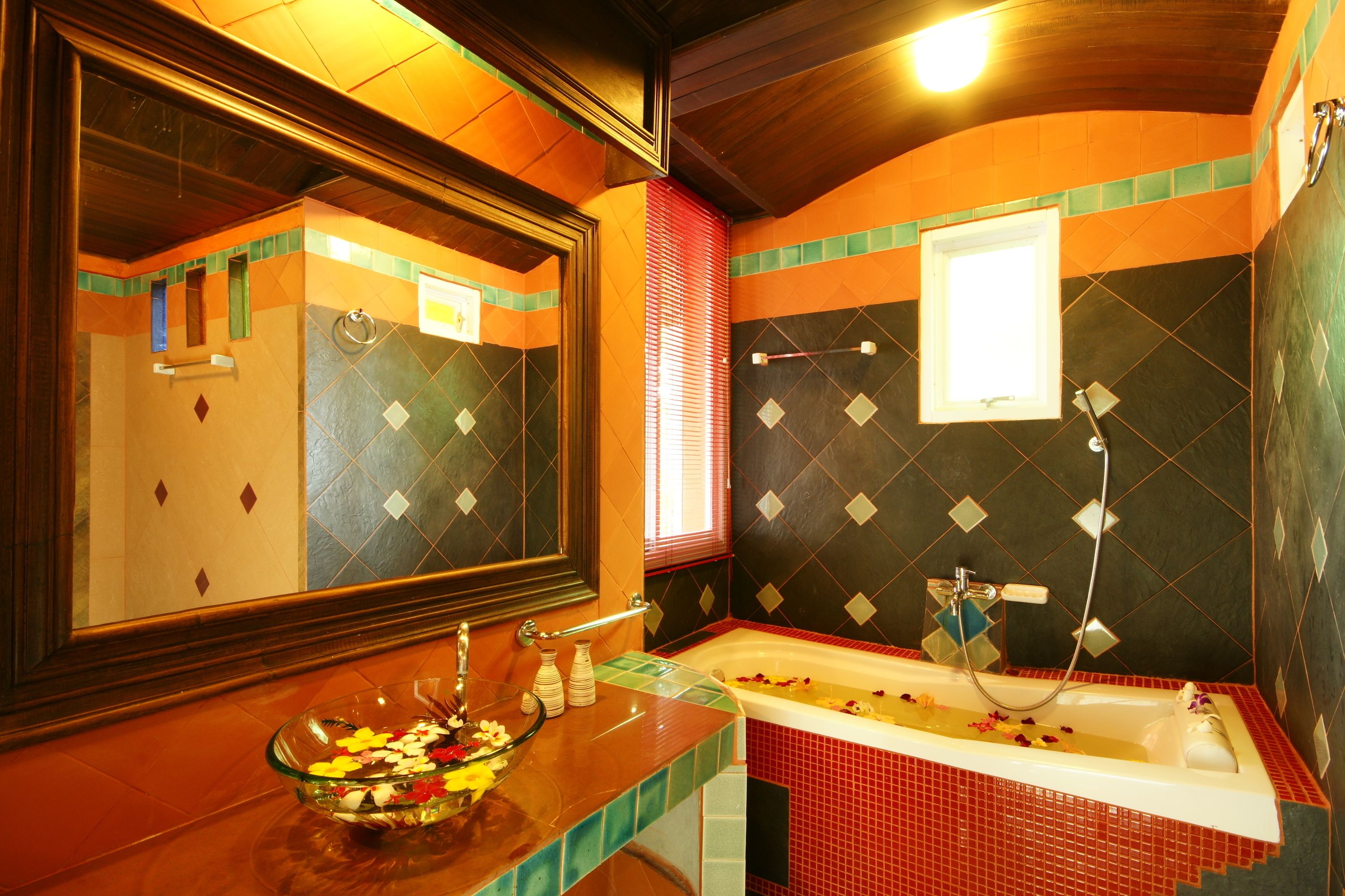 A bathroom with a glass bowl on the counter, a bathtub, and a mirror.