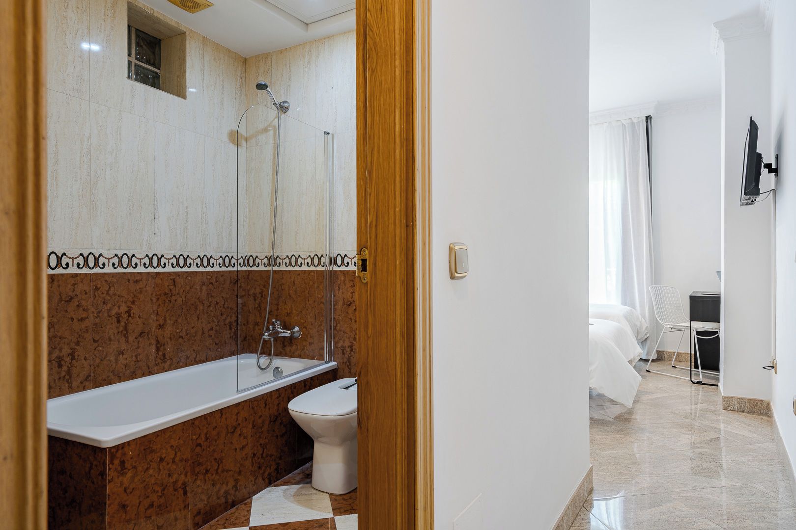 Een moderne badkamer met douche, toilet en wastafel.