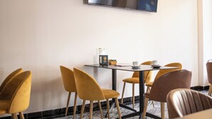 A conference room with a table, chairs, and a television mounted on the wall. - Hotel Agur (Fuengirola)