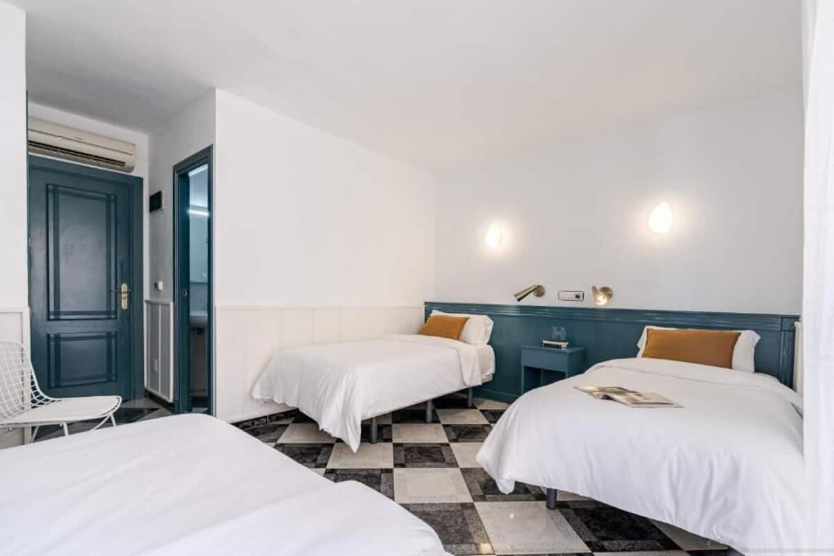 Ett hotellrum med två sängar, ett litet skrivbord och en stol.