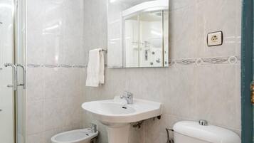 Un baño con un lavamanos blanco, un bidé y un inodoro.
